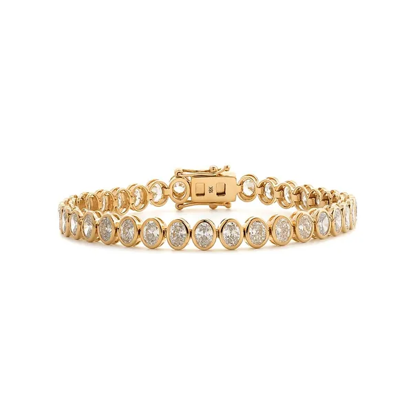 Yellow gold bracelet set with a row of oval clear stones in bezel settings.
