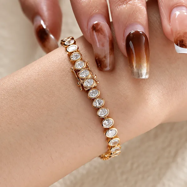 A yellow gold bracelet with a row of oval clear stones in bezel settings.