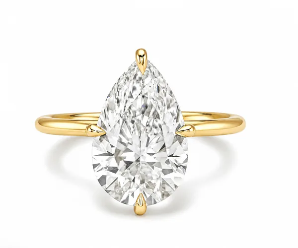 A large pear-shaped clear stone sits in a yellow-gold ring with visible prongs.