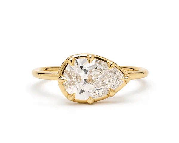 Yellow-gold ring with a large round and pear-shaped clear stones in prong settings.