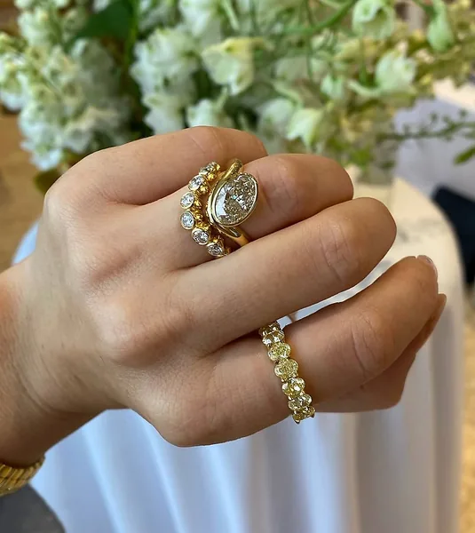 A gold ring with a large oval stone beside a row of smaller round stones.