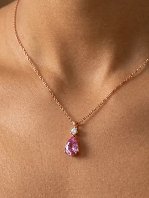 Pink pear-shaped pendant below a small white cluster on a fine chain