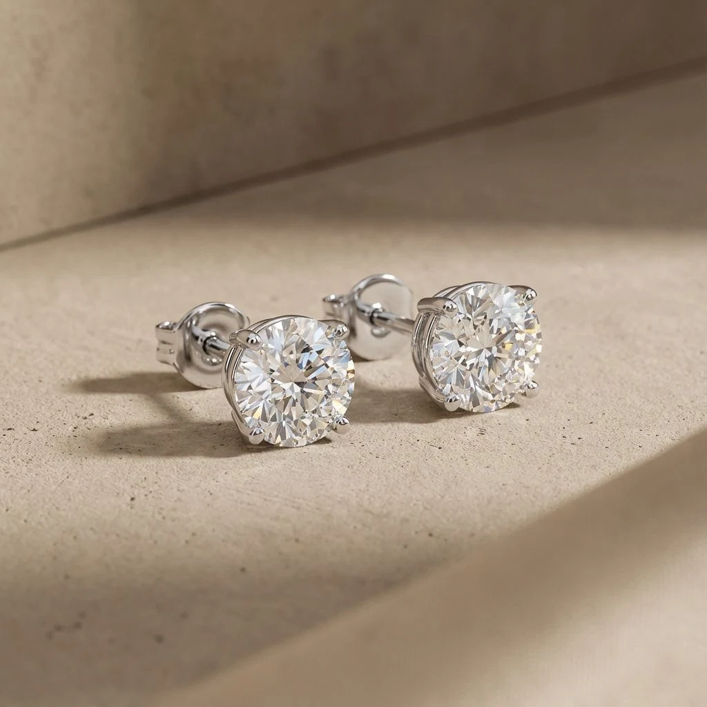 Pair of round white-stone studs resting on a pale surface