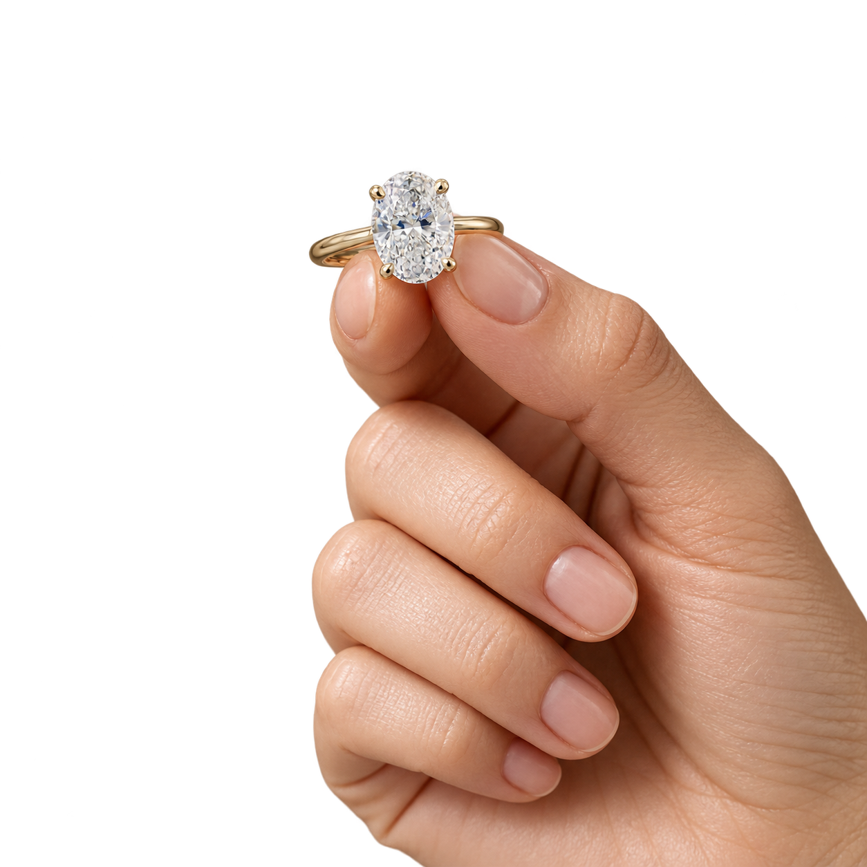 An oval diamond ring held lightly between fingertips